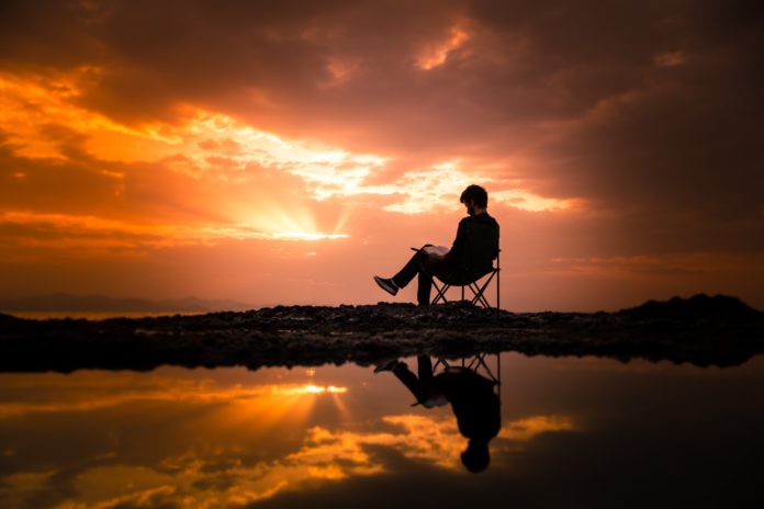 Man writing at sunset